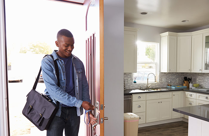 Man unlocking front door and walking inside home.