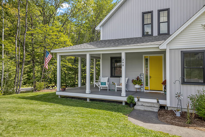 Grey home with bright yellow front door.